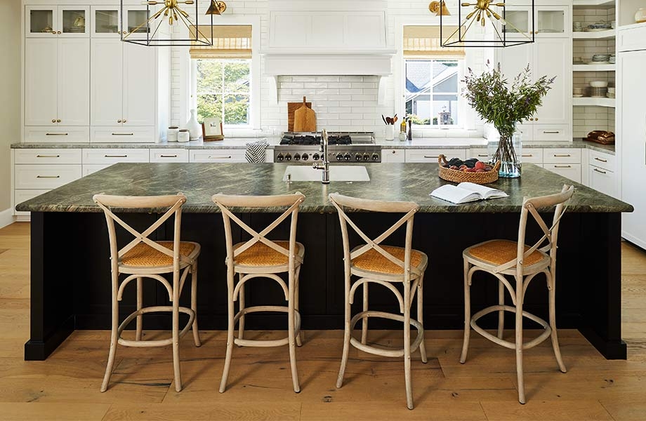 Large kitchen with white cabinets and backsplash, midcentury chandeliers and island with Jatoba Green 180fx Laminate countertop with chairs
