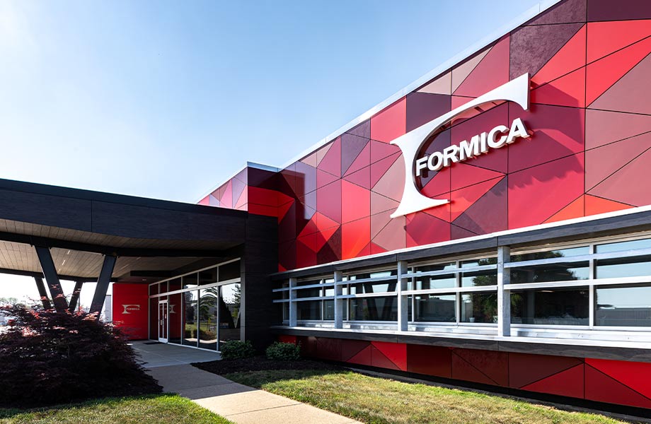 Exterior of Formica Group building headquarters with windows, red geometric panels and large corporate logo