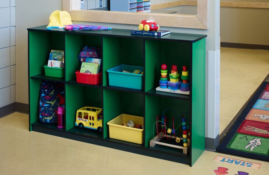 Green shelving unit with toys in a playroom
